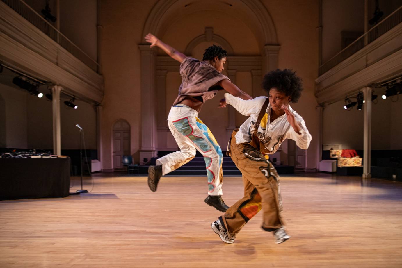 Two performers one jumping and the other pushing off in close proximity.